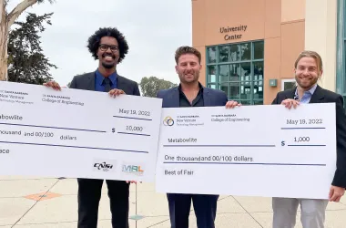 Entrepreneurs pose with large check displays indicating $10,000 and $1,000 in award money.